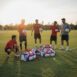 Time de futebol reunido em volta de suas boldas personalizadas.