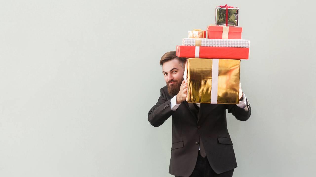 Homem segurando brindes que serão dados aos colaboradores em data celebrativas.