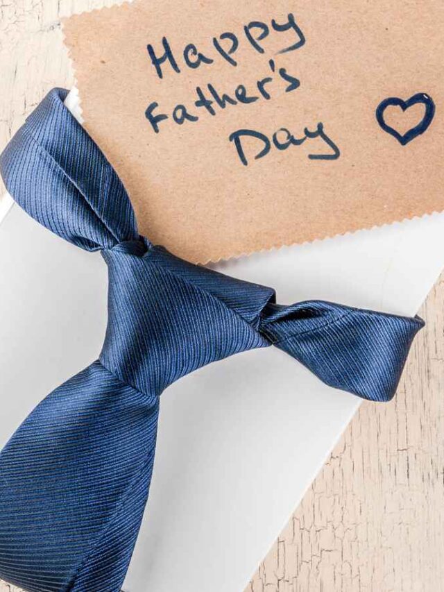 Caixa de brinde branca amarrada com uma gravata azul marinho e cartão escrito “Happy Father’s Day” ao lado.