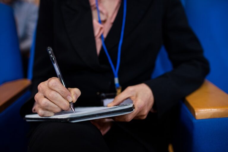 Mulher anotando quais os critérios obrigatórios e não obrigatórios para criar uma CIPA e realizar o evento SIPAT.