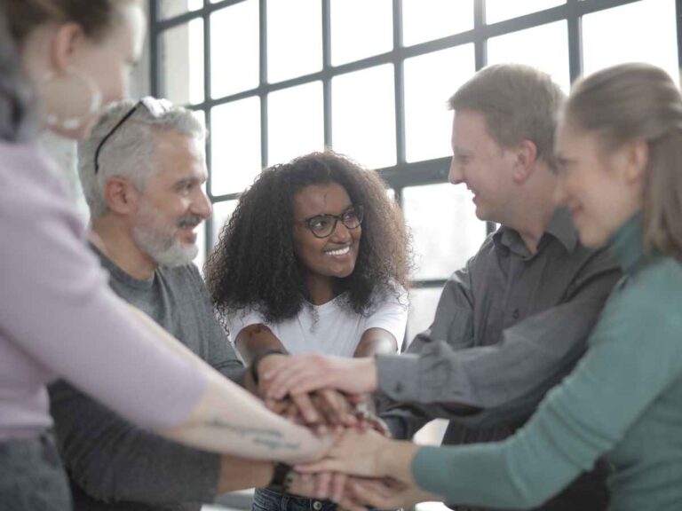 Nova colaboradora feliz após a finalização do processo de integrar novos funcionários, enquanto comemora com os outros membros da sua equipe sua chegada.