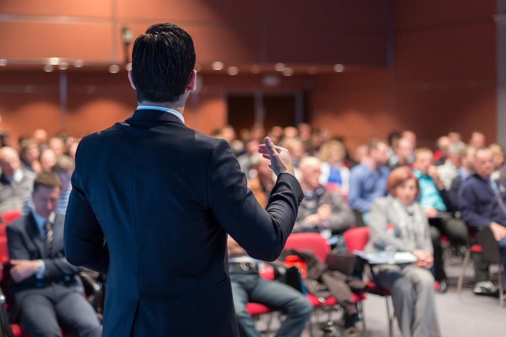 homem fazendo palestra em evento corporativo