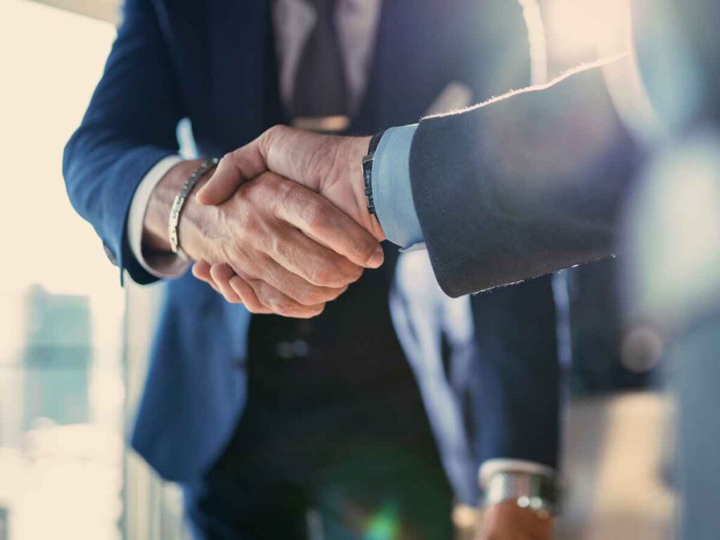 CEO de uma empresa fechando parceria com o dono de uma instituição de ensino.
