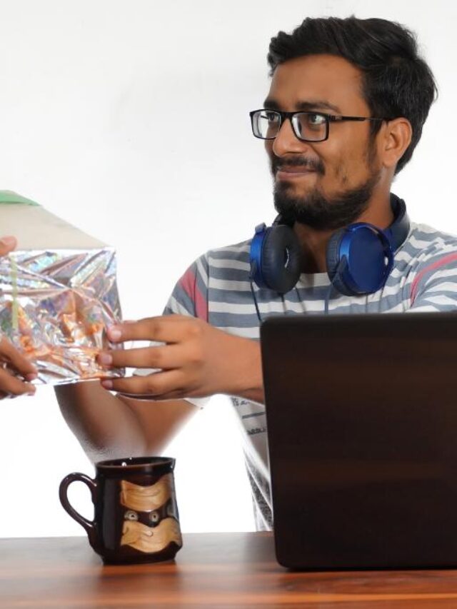 Funcionário recebendo um brinde enquanto trabalha em sua mesa com computador