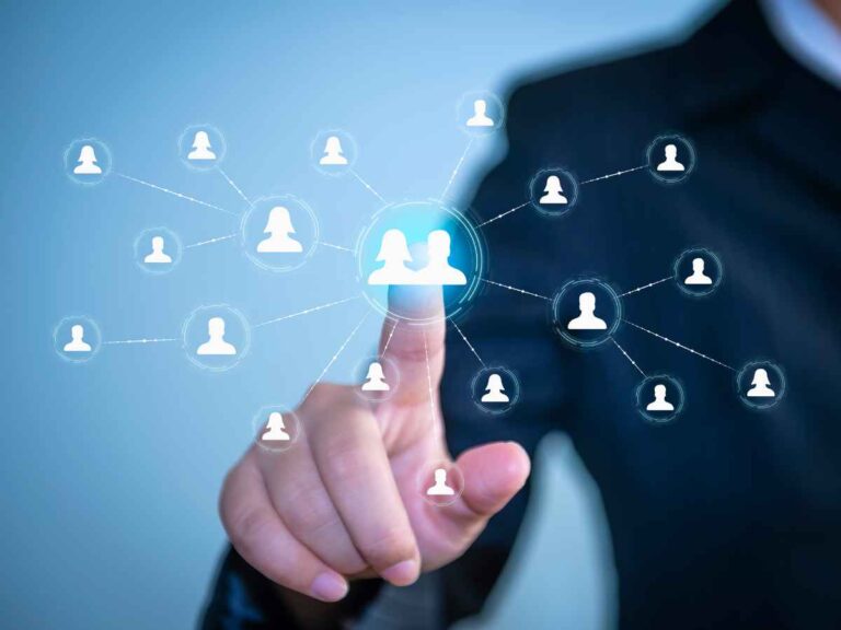 Dono de empresa tocando uma interface digital com ícones de perfis humanos conectados por linhas, representando uma rede de networking profissional.