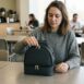 Mulher sentada em refeitório de empresa começando a abrir sua bolsa térmica para marmita.