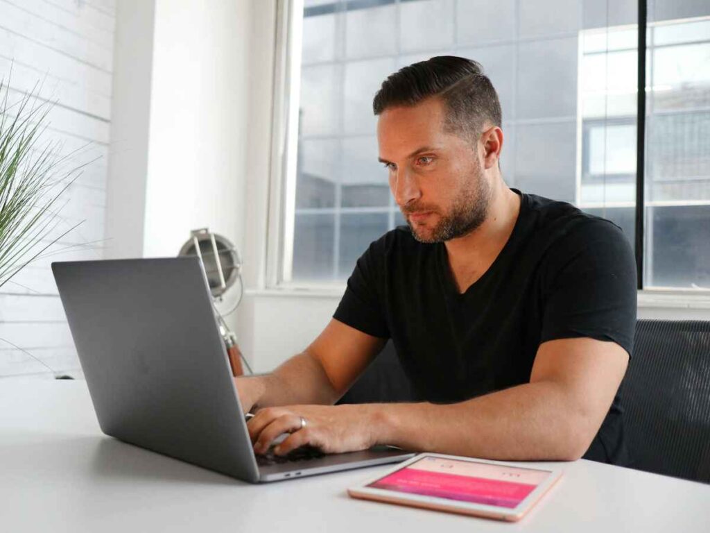 Homem concentrado usando notebook em um escritório moderno, simbolizando a busca por técnicas de personalização e planejamento estratégico.