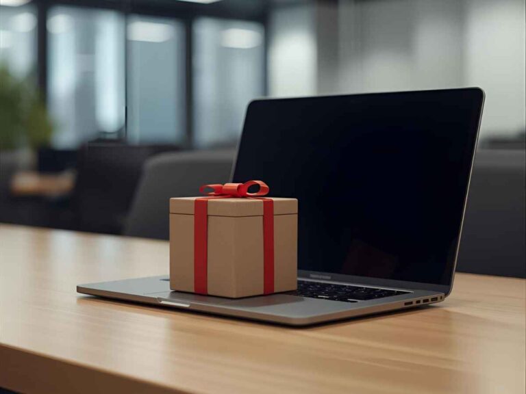 Presente com laço vermelho sobre um notebook em uma mesa de escritório