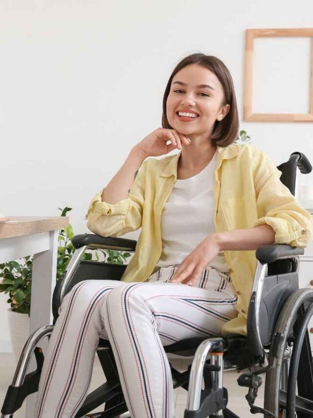 mulher em cadeira de rodas sorrindo ao lado de mesa organizada com presente decorado