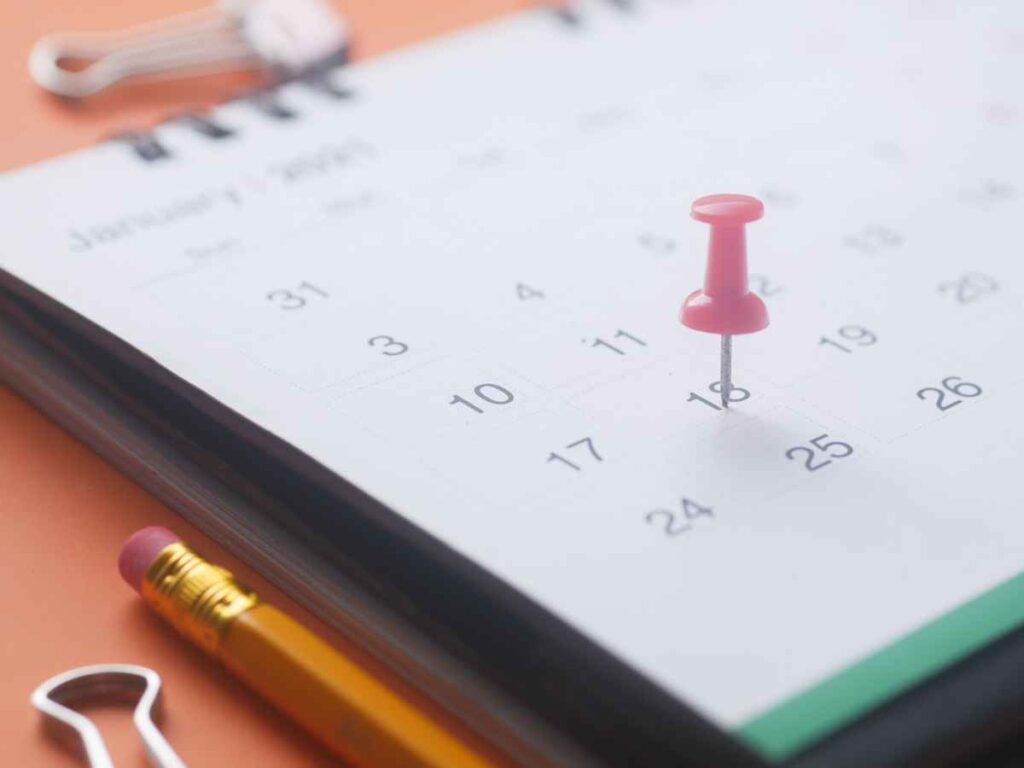 Calendário com alfinete rosa marcando uma data importante para planejamento.