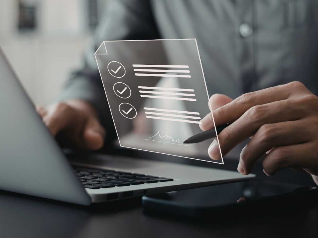 Pessoa assinando documento digital em notebook com interface de checklist exibida na tela.