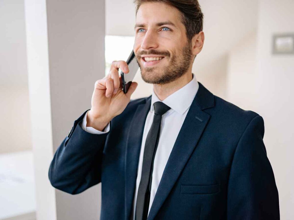 Homem falando no celular para encomendar mochilas personalizadas