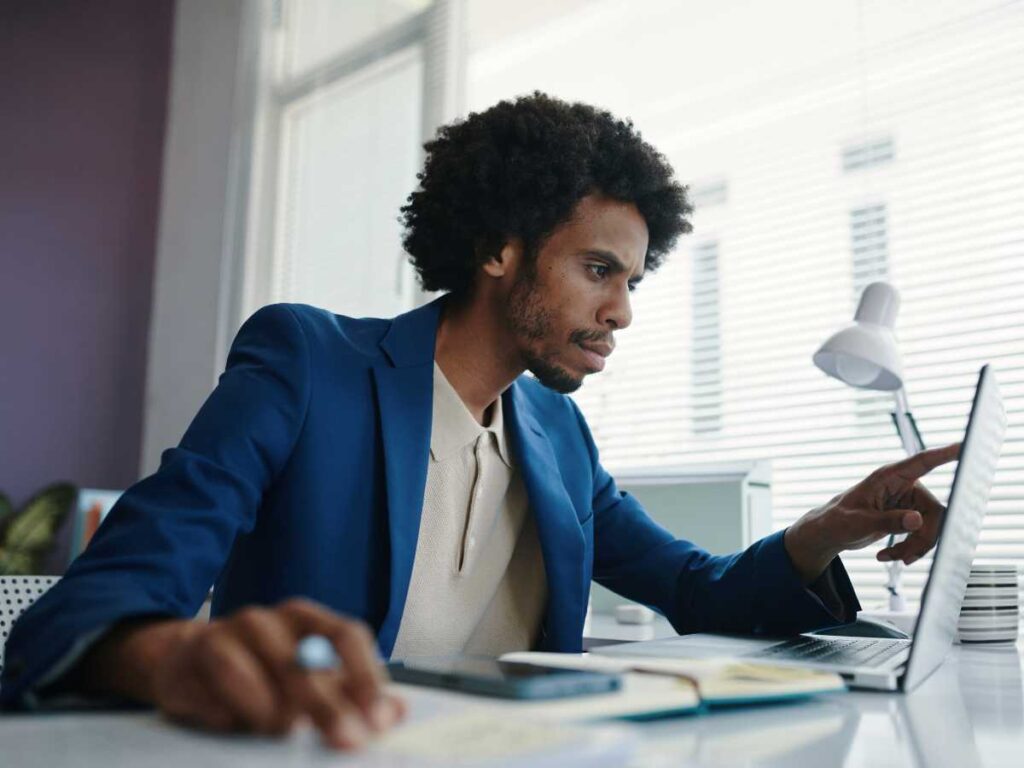 Homem analisando informações e dados em notebook