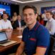 Colaborador da Espn sentado em mesa de reunião, ele usa uma camisa polo da empresa.